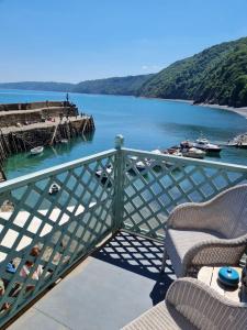 a view of a body of water with two chairs at Red Lion Hotel in Clovelly