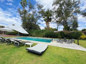 una piscina con tumbonas y sombrillas junto a en Increíble casa familiar c/ alberca climatizada!, en Yautepec