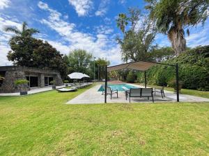 una piscina con pabellón, mesa y bancos en Increíble casa familiar c/ alberca climatizada!, en Yautepec