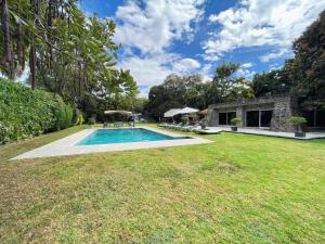 un patio con piscina y una casa en Increíble casa familiar c/ alberca climatizada!, en Yautepec