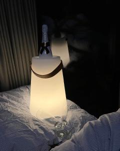 a bottle of wine sitting on top of a bed at Aurora Hut by InukTravel in Nuuk