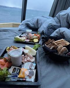 een dienblad met eten op een bed bij Aurora Hut by InukTravel in Nuuk