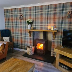 a living room with a wood burning stove at North Coast Property - 17 Margaret Street - Avoch in Avoch
