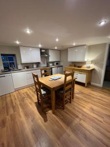 a kitchen with a wooden table and chairs in it at North Coast Property - 17 Margaret Street - Avoch in Avoch