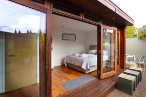 a bedroom with a bed and a sliding glass door at Cedar House Canterbury in Canterbury