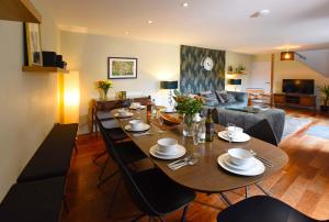 a dining room and living room with a table and chairs at Cedar House Canterbury in Canterbury
