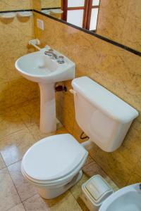 a bathroom with a toilet and a sink at Hotel Villa Sol in Merlo