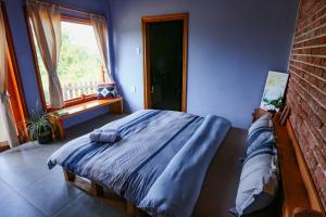 um quarto com uma cama com lençóis azuis e uma janela em Pinky Moon House Măng Đen em Kon Von Kla