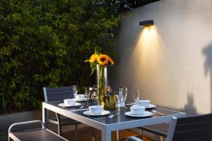 Cedar House Canterbury في كانتربيري: طاولة مع مزهرية عليها عبقة الشمس