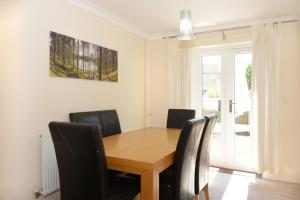 a dining room with a wooden table and black chairs at Stylish 4-bedroom House In The Heart Of The City With Free Parking! in Southampton