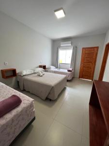 een hotelkamer met 2 bedden en een raam bij Pousada Rosália in Penha