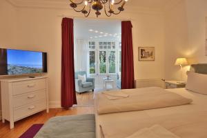 een slaapkamer met een bed en een flatscreen-tv bij Villa Schöneck Villa Schöneck Appartement 2 in Scharbeutz