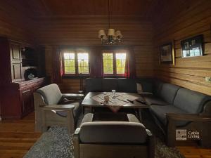 uma sala de estar com um sofá e uma mesa em Solid and cozy cottage in a secluded location em Beitostøl