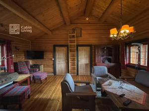 una sala de estar en una cabaña de madera con techo de madera en Solid and cozy cottage in a secluded location en Beitostøl