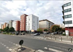 une rue urbaine vide avec des bâtiments et des voitures sur la route dans l'établissement 2 PIECES proche du centre PARIS 15 min, à Rosny-sous-Bois