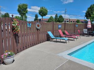 a fence with chairs next to a swimming pool at Ashley Quarters Hotel in Florence