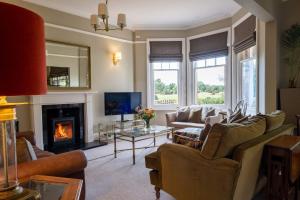 a living room with couches and a fireplace at Surrey Lodge in Brockenhurst
