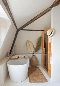 uma casa de banho com uma banheira branca e um lavatório. em Het sfeerhuis aan zee em Vlissingen