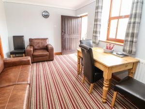 een woonkamer met een tafel en stoelen en een bank bij Haddon Cottage in Bakewell