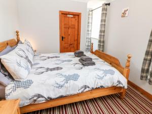 een slaapkamer met een bed met een houten frame bij Haddon Cottage in Bakewell