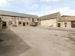 an empty parking lot in front of two brick buildings at Haddon Cottage in Bakewell
