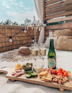 einen Tisch mit einem Tablett mit Käse und Gläsern Wein in der Unterkunft Het sfeerhuis aan zee in Vlissingen