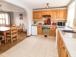eine Küche mit Holzschränken und ein Esszimmer mit einem Tisch in der Unterkunft The Tom Wragg Suite in Bakewell