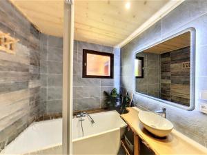 a bathroom with a tub and a sink and a bath tub at Chalet spacieux avec billard, proche des remontées mécaniques, idéal pour familles et cyclistes - FR-1-267-174 in Le Corbier +19 photos
