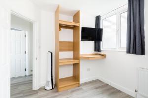 a room with a book shelf and a tv at MA Kenilworth in Kenilworth