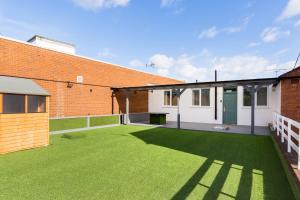 a large yard with green grass next to a brick building at MA Kenilworth in Kenilworth