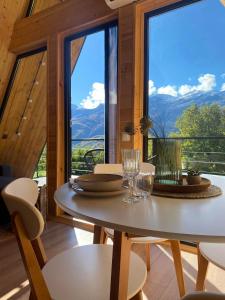 a table and chairs in a room with a large window at Roots Svaneti ' რუთს სვანეთი in Lentekhi