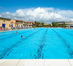 a large swimming pool with people in the water at Continental Resort in Tirrenia