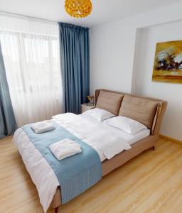 sypialnia z dużym łóżkiem z białą pościelą i poduszkami w obiekcie Le Blanc ApartHotel w Bukareszcie