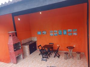 a room with a fireplace and a table and chairs at Casa com piscina em Mongaguá in Mongaguá