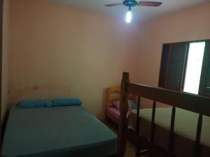 una camera da letto con due letti e un ventilatore a soffitto di Casa com piscina em Mongaguá a Mongaguá Altre 10 foto