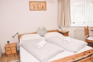 1 dormitorio con 2 camas y toallas. en Pension s'Platzl Stuhleck en Spital am Semmering