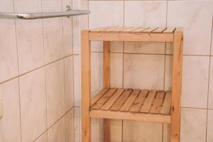 La salle de bains est pourvue d'une douche et d'une étagère en bois. dans l'établissement Pension s'Platzl Stuhleck, à Spital am Semmering