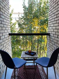 a balcony with two chairs and a table on a balcony at Modern & Rustic Apartment - City Center. in Pristina