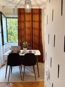 a dining room table with a laptop computer on it at Modern & Rustic Apartment - City Center. in Pristina
