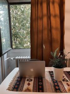 a laptop computer sitting on a table in front of a window at Modern & Rustic Apartment - City Center. in Pristina