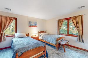 a bedroom with two beds and two windows at Gilford's Delight in Gilford