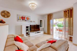 ein Wohnzimmer mit einem Sofa und einem TV in der Unterkunft Ocean View Duplex Tenerife ( Golf del Sur) in San Miguel de Abona