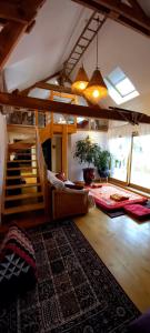 a living room with a staircase and a rug at Un parfum de Thaïlande, ressourcement et massages in Curemonte