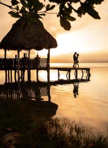 a couple kissing on a pier near the water at Hotel Gringo Perdido in El Remate