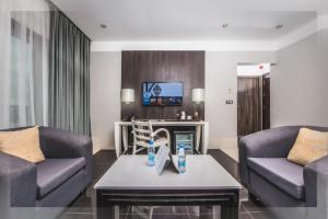 sala de estar con 2 sofás y TV en Krystal Palace Douala en Douala