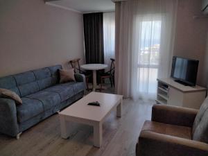 a living room with a couch and a tv and a table at Silver Tower Residence in Kusadası