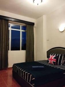 een slaapkamer met een bed en een groot raam bij GloRy BeAch ResOrt private apartment in Port Dickson