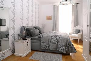 ein Schlafzimmer mit einem Bett, einem Sofa und einem Spiegel in der Unterkunft Luxusní apartmán s empírovými freskami v centru Čáslavi in Čáslav