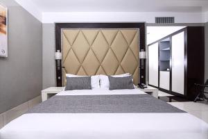 a bedroom with a large bed with a large headboard at Krystal Palace Douala in Douala