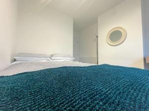 a bedroom with a bed with a blue blanket at Cosy & Comfortable - Heart of Hove - Beach Getaway in Brighton & Hove +3 photos